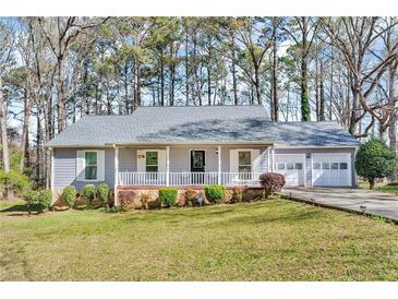 Charming single-story home with a well-manicured lawn and attached two car garage at 8698 Twin Oaks Dr, Jonesboro, GA 30236
