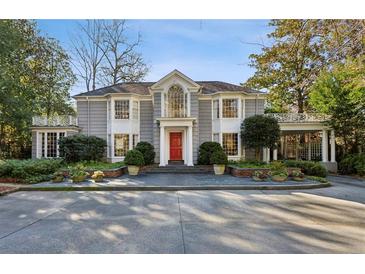 Stately two-story home with a red front door, beautiful bay windows and manicured landscaping at 2820 Andrews Nw Dr, Atlanta, GA 30305