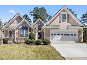 Charming home with a well-manicured lawn, a two-car garage, and a stone-accented entrance at 407 Black Fox Dr, Locust Grove, GA 30248