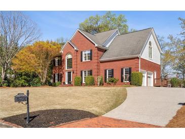 Charming two-story brick home with well-maintained landscaping and a curved driveway at 12600 Silver Fox Court, Roswell, GA 30075