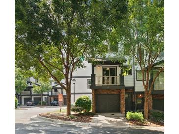 Inviting townhouse exterior with lush landscaping, a private balcony, and an attached garage at 215 Semel Nw Dr # 466, Atlanta, GA 30309
