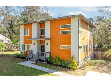 Modern two-story home featuring a unique orange and white exterior, complemented by well-maintained landscaping and large windows at 576 Quillian Ave, Decatur, GA 30032