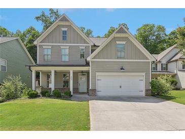 Charming two-story home with a well-manicured lawn and a welcoming covered front porch at 557 Winder Trl, Canton, GA 30114
