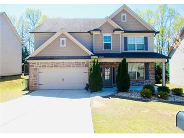 Charming two-story home featuring stone accents, well-manicured lawn, and a two-car garage at 1980 Beyers Landing Dr, Buford, GA 30519