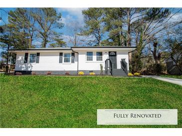 Charming renovated single-story home featuring black trim, front lawn, and beautiful landscaping at 3762 Larkspur Ter, Decatur, GA 30032