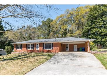 Charming single story brick home with a long driveway, carport, and well-maintained lawn at 4162 Brownlee Dr, Tucker, GA 30084