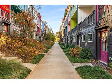 Colorful townhomes line a walkway with manicured landscaping and vibrant curb appeal at 140 Color Cir, Atlanta, GA 30317