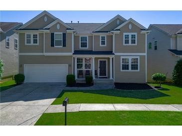 Charming two-story home featuring well-maintained lawn and attached two-car garage, offering curb appeal and convenience at 1218 Lanier Springs Dr, Buford, GA 30518
