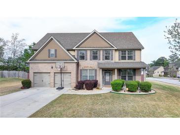 Charming two-story home with a well-manicured lawn, two car garage and a basketball hoop at 9 Oatgrass Dr, Grayson, GA 30017
