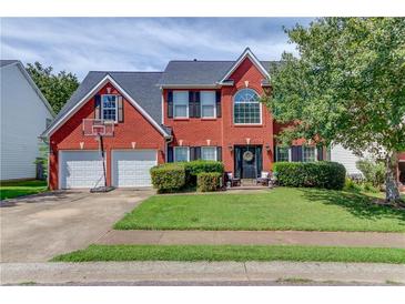 Charming two-story red brick home with well-maintained lawn, two-car garage, and landscaped front yard at 1312 Woodland View Rd, Lawrenceville, GA 30043