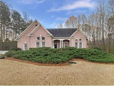 Charming pink brick home featuring manicured landscaping and a welcoming front porch at 2688 Kelly Cove Dr, Buford, GA 30519