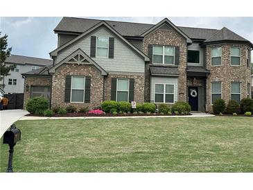 Beautiful brick and siding two-story home with a well-manicured lawn and landscaping at 4030 Amberhill Cir, Cumming, GA 30040