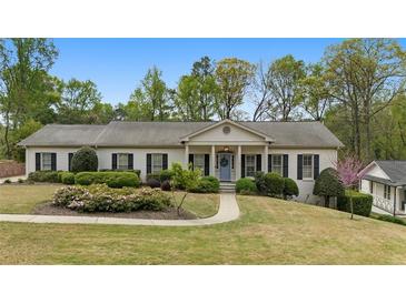 Charming single-story home with manicured lawn, mature trees, and a welcoming front porch at 1724 Ridge Valley Nw Ct, Atlanta, GA 30327