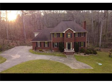 Charming two-story brick home with well-manicured lawn and circular driveway at 30 Woodbrook Ct, Mcdonough, GA 30252