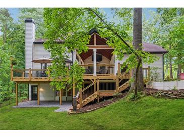 A spacious back deck with multiple seating areas is accessible by a staircase at 950 Ivy St, Cumming, GA 30041