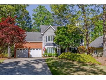 Charming two-story home featuring a brick and gray facade with an attached two-car garage at 3107 Sandhurst Dr, Woodstock, GA 30189