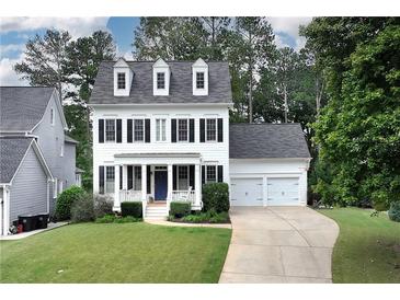 Charming two-story home featuring a well-manicured lawn, symmetrical design and an attached two car garage at 6335 Hampton Creek Dr, Cumming, GA 30041