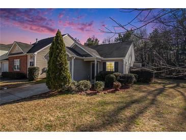 Charming home featuring a well-manicured lawn and inviting curb appeal under a stunning sky at 1025 Lakeside Circle, Covington, GA 30016