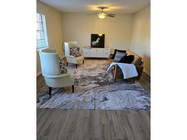 Bright living room featuring stylish furnishings, a modern ceiling fan and marble style rug at 6354 Shannon Pkwy # 15D, Union City, GA 30291