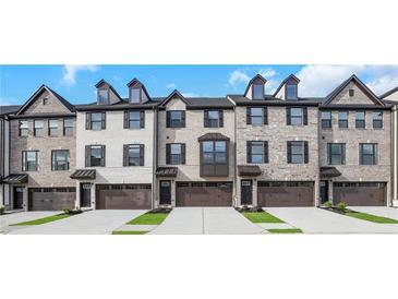 Charming brick townhomes feature symmetrical windows, private garage, and inviting curb appeal at , Lawrenceville, GA 30046