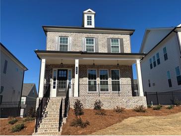 Charming two-story home with a brick facade, covered porch, and manicured front yard at 122 Stonehouse Dr, Cumming, GA 30040
