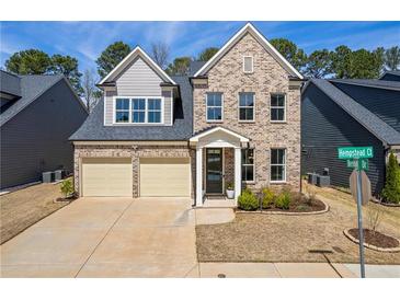 Charming two-story brick home with a two-car garage and manicured front yard in a desirable neighborhood at 2121 Hempstead Ct, Snellville, GA 30078
