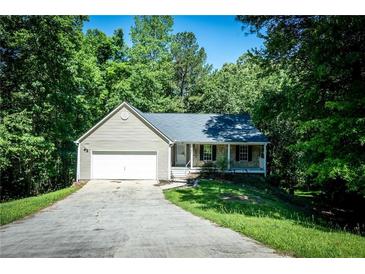 Charming home with a one-car garage and a stone-accented front porch nestled among mature trees at 3013 Rockview Dr, Loganville, GA 30052