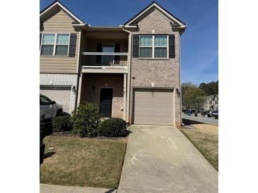 Charming two-story townhome with a brick facade, balcony, and single-car garage at 1831 Broad River Rd, Atlanta, GA 30349