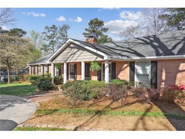 Charming brick home with a manicured lawn and inviting front porch at 1566 Arden Sw Dr, Marietta, GA 30008