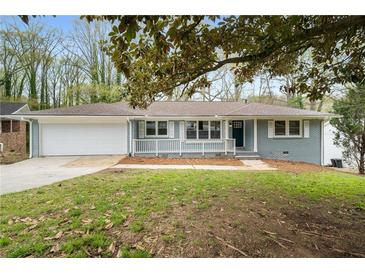 Charming single-story home with a painted brick facade, attached garage, and inviting front porch at 3069 Thrasher Cir, Decatur, GA 30032