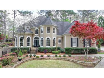 Stately two-story home with a manicured front lawn, tasteful landscaping, and an elegant facade at 803 Amerden Ponds Ct, Johns Creek, GA 30097