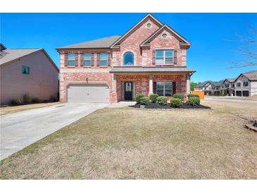 Charming brick home featuring a well-manicured lawn and inviting front entrance at 910 Shannon Mist Dr, Loganville, GA 30052