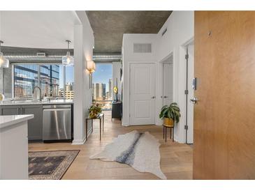 Modern condo entryway featuring hardwood floors, stylish decor, and a view of the city skyline at 923 Peachtree Ne St # 939, Atlanta, GA 30309