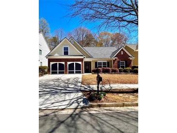 Charming home with brick and siding, a two-car garage, and manicured bushes at 779 Harvest Brook Dr, Lawrenceville, GA 30043