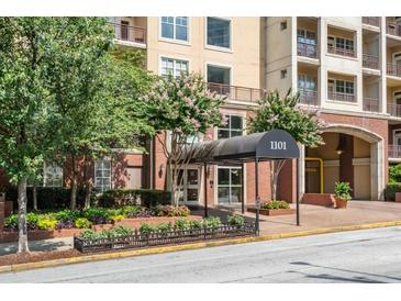 Inviting condo building entrance with covered awning and manicured landscaping at 1101 Juniper Ne St # 612, Atlanta, GA 30309