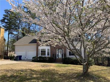 Charming two-story home with brick accents, a two-car garage, and a beautiful flowering tree in the front yard at 645 Legend Sw Ct, Atlanta, GA 30331