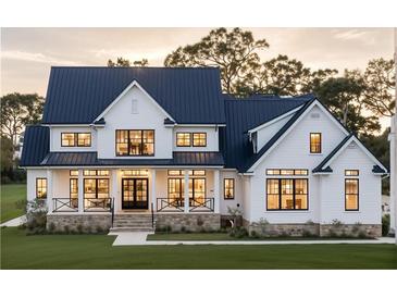 Stunning two-story home featuring a modern farmhouse design, a well-manicured lawn, and a welcoming front porch at 152 Sherwood Ln, Canton, GA 30115
