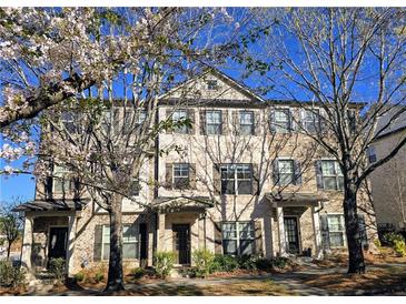 Beautiful brick townhome exterior with blooming trees in a well-maintained community at 1560 Baygreen Rd, Suwanee, GA 30024