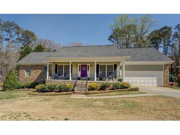 Inviting single-story home featuring a covered front porch, stone accents, and a charming purple front door at 802 Sugar Creek Se Dr, Conyers, GA 30094
