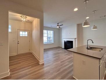 Bright living room featuring a fireplace, ceiling fan, and wood-look flooring at 1910 Victoria Way # 120, Conyers, GA 30013