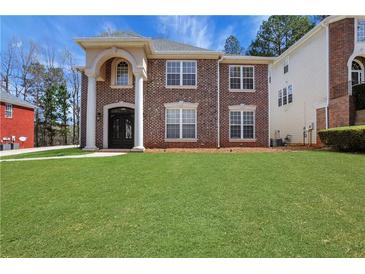 Charming two-story brick home with a well-manicured lawn at 3485 Walnut Rdg, Atlanta, GA 30349