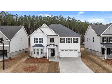Charming two-story home showcasing a white exterior, black shutters, and a well-manicured lawn at 13567 Tolstoy Drive, Covington, GA 30014