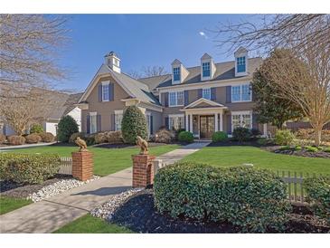 Charming home with a manicured lawn, beautiful landscaping, and detailed architectural design at 3740 Williams Point Dr, Cumming, GA 30028
