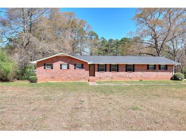 Charming brick home with a well-maintained lawn and mature trees at 1420 Stephenson Rd, Lithonia, GA 30058