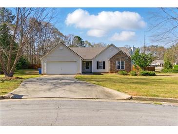 Charming single Gathering home featuring a two-car garage, well-maintained lawn, and partial stone accents at 1715 Eden Valley Ct, Loganville, GA 30052