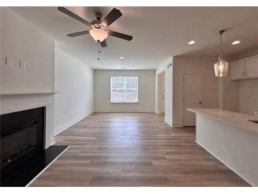 Bright living room featuring fireplace, ceiling fan and wood-look flooring at 1812 Emory Ln # 93, Conyers, GA 30013