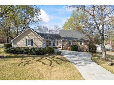 Charming home featuring a stone facade and a long driveway nestled amongst mature trees at 2019 Wiltshire Pl, Snellville, GA 30078