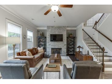 Inviting living room featuring a stone fireplace, hardwood floors, and abundant natural light at 2022 Raven Way, Atlanta, GA 30341