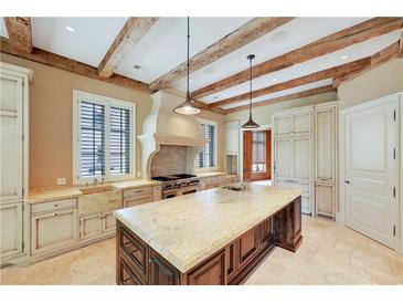 Spacious kitchen features a large island, granite counters, and exposed wooden beams overhead at 2440 Peachtree Nw Rd # 22, Atlanta, GA 30305