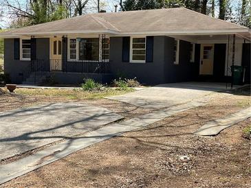 Charming single-story home with a well-maintained yard and covered porch and driveway at 1271 Sanders Dr, Lake City, GA 30260